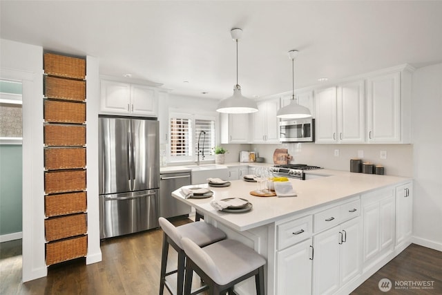 2643A NW 59th St, Seattle, WA 98107 - kitchen featuring stainless steel appliances, light countertops, dark wood-style flooring, a peninsula, and white cabinetry
