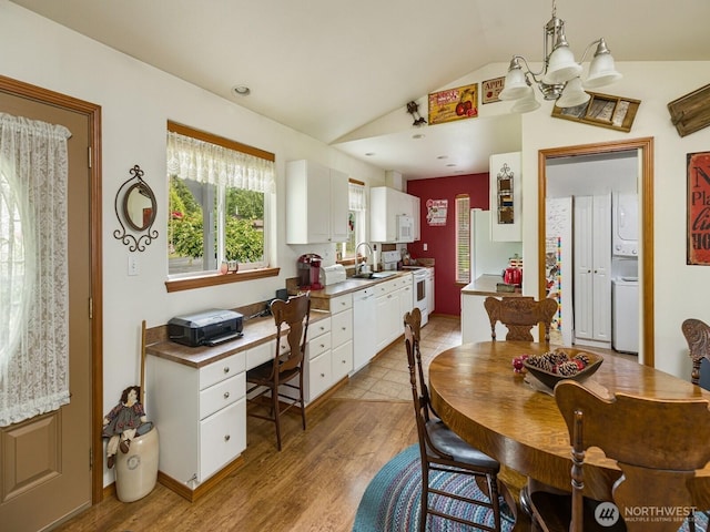 290 E Budd Dr, Shelton, WA 98584 - dining area with vaulted ceiling, stacked washer and clothes dryer, wood finished floors, and a chandelier