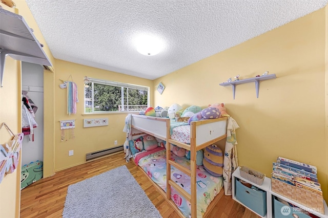 2 Quinault Way, La Conner, WA 98257 - bedroom featuring a textured ceiling, a baseboard radiator, and wood finished floors