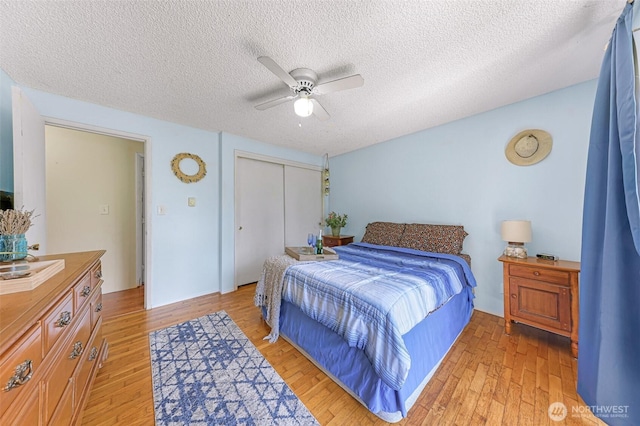 2 Quinault Way, La Conner, WA 98257 - bedroom with light wood-style floors, a closet, a ceiling fan, and a textured ceiling