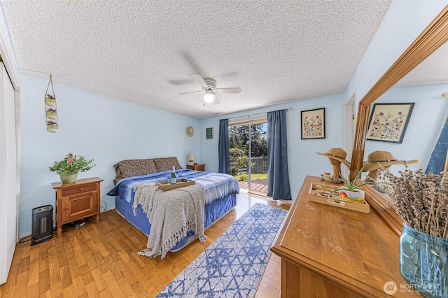 2 Quinault Way, La Conner, WA 98257 - bedroom with access to exterior, light wood-type flooring, a textured ceiling, and a ceiling fan