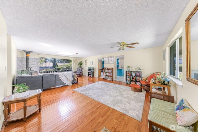 2 Quinault Way, La Conner, WA 98257 - living room featuring a textured ceiling, a wood stove, wood finished floors, and a ceiling fan