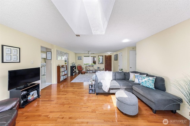 2 Quinault Way, La Conner, WA 98257 - living area with light wood-style flooring, a textured ceiling, and a skylight