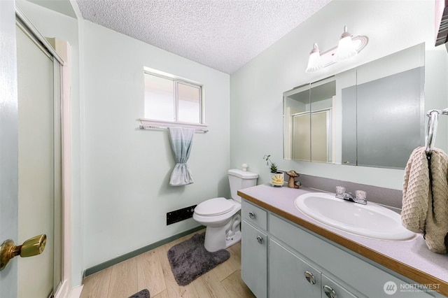 2 Quinault Way, La Conner, WA 98257 - bathroom with a stall shower, a textured ceiling, wood finished floors, vanity, and toilet
