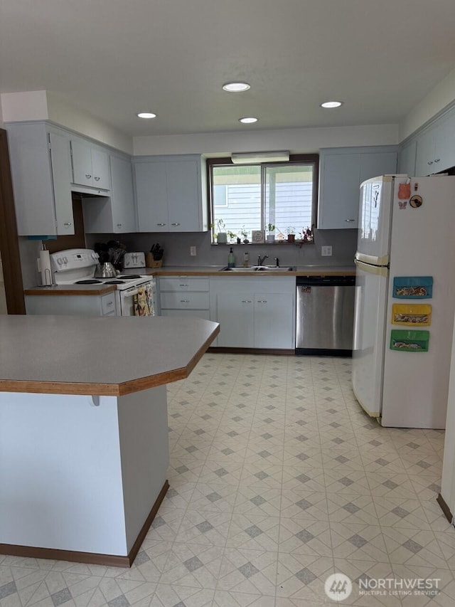 2 Quinault Way, La Conner, WA 98257 - kitchen with white appliances, a sink, a peninsula, and light flooring