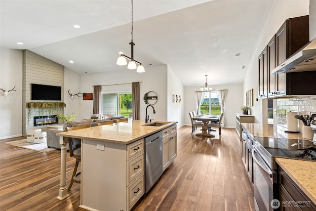 144 Faun Rae Ln, Chehalis, WA 98532 - kitchen with a fireplace, appliances with stainless steel finishes, a sink, a chandelier, and wall chimney range hood