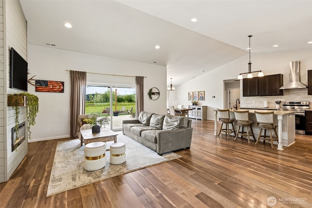 144 Faun Rae Ln, Chehalis, WA 98532 - living room featuring vaulted ceiling, wood finished floors, a large fireplace, baseboards, and recessed lighting