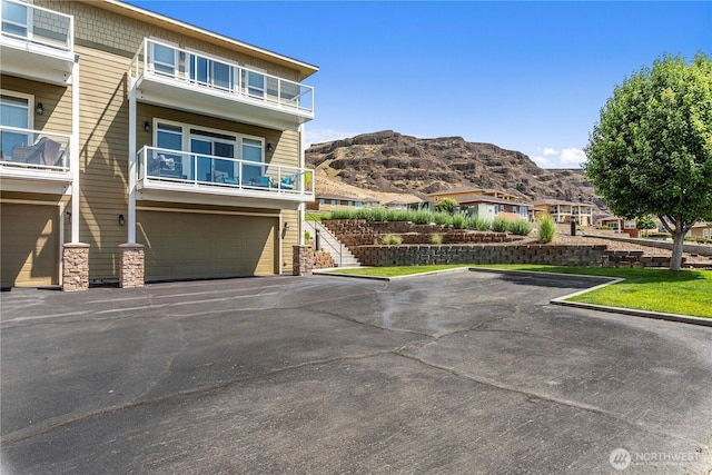 9159 Riverview Way NW Unit D39, Quincy, WA 98848 - view of front of home featuring a mountain view, an attached garage, a balcony, and asphalt driveway