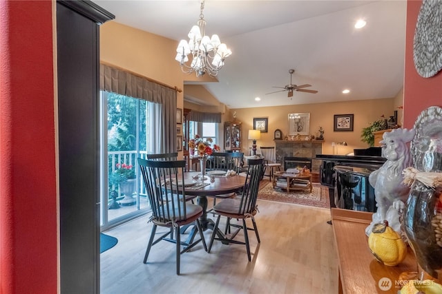 22 Inlet Cir, Bellingham, WA 98229 - dining room featuring light wood finished floors, vaulted ceiling, a ceiling fan, a glass covered fireplace, and a chandelier