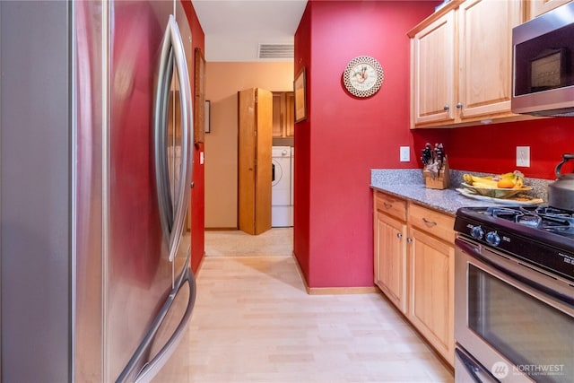 22 Inlet Cir, Bellingham, WA 98229 - kitchen with appliances with stainless steel finishes, washer / dryer, light brown cabinetry, and light wood-type flooring