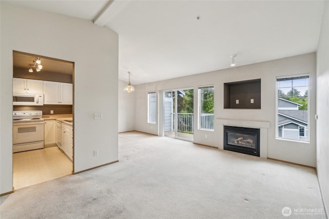 15150 140th Way SE Unit T304, Renton, WA 98058 - unfurnished living room with healthy amount of natural light, light carpet, a chandelier, and a glass covered fireplace