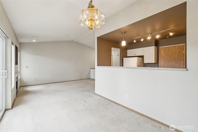 15150 140th Way SE Unit T304, Renton, WA 98058 - unfurnished living room with a chandelier, light colored carpet, vaulted ceiling, baseboards, and rail lighting