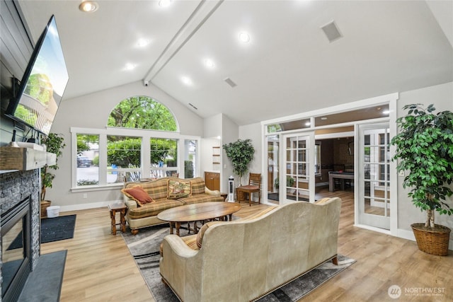 15150 140th Way SE Unit T304, Renton, WA 98058 - living room with french doors, a stone fireplace, wood finished floors, beam ceiling, and baseboards
