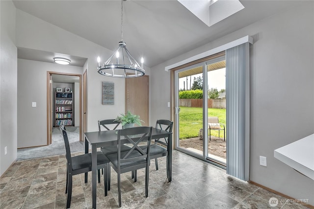 56065608 76th Street Ct E, Puyallup, WA 98371 - dining room with vaulted ceiling, a chandelier, baseboards, stone finish floors, and a skylight