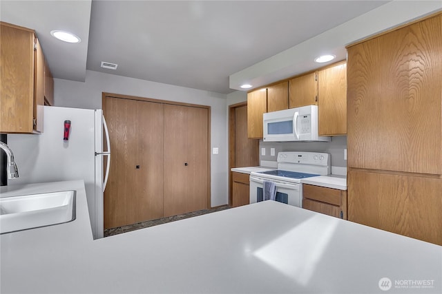 56065608 76th Street Ct E, Puyallup, WA 98371 - kitchen featuring white appliances, light countertops, recessed lighting, brown cabinetry, and a sink