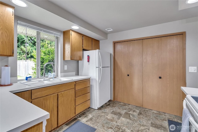 56065608 76th Street Ct E, Puyallup, WA 98371 - kitchen featuring freestanding refrigerator, a sink, light countertops, range, and stone finish flooring