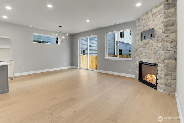8010 222nd St SW, Edmonds, WA 98026 - unfurnished living room featuring light wood-type flooring, a chandelier, a fireplace, baseboards, and recessed lighting