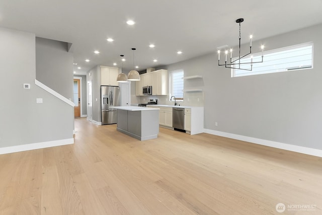 8010 222nd St SW, Edmonds, WA 98026 - kitchen with stainless steel appliances, a kitchen island, light wood-style floors, light countertops, and a chandelier