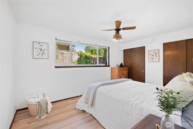 22412 110th Ave SE, Kent, WA 98031 - bedroom featuring wood finished floors, multiple closets, baseboards, and a ceiling fan
