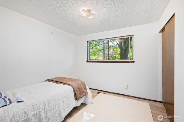 22412 110th Ave SE, Kent, WA 98031 - bedroom with wood finished floors, a textured ceiling, and baseboards