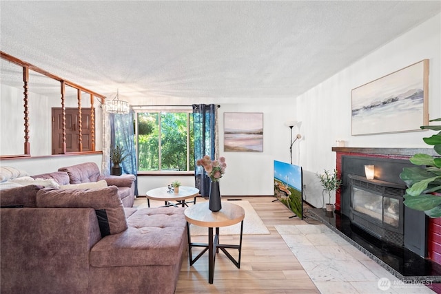 22412 110th Ave SE, Kent, WA 98031 - living area featuring a textured ceiling, light wood finished floors, a chandelier, and baseboards