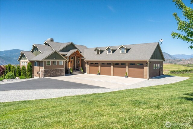 653 Lakayuse Rd, Manson, WA 98831 - view of front facade featuring a mountain view, driveway, board and batten siding, a front lawn, and stone siding