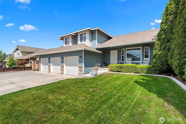 2562 Fancher Heights Blvd, East Wenatchee, WA 98802 - tri-level home featuring concrete driveway, a porch, an attached garage, a shingled roof, and stone siding