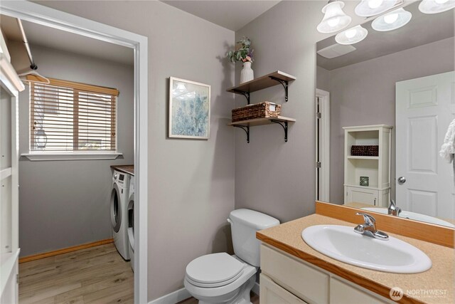 2562 Fancher Heights Blvd, East Wenatchee, WA 98802 - bathroom with washer and clothes dryer, wood finished floors, toilet, vanity, and baseboards
