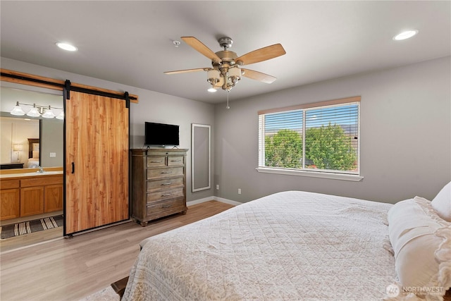 2562 Fancher Heights Blvd, East Wenatchee, WA 98802 - bedroom featuring light wood-type flooring, recessed lighting, a barn door, baseboards, and a sink