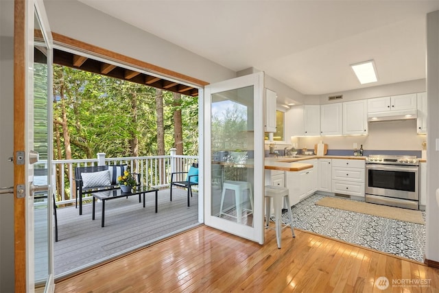 24390 Mount Washington View Ln NW, Poulsbo, WA 98370 - kitchen featuring stainless steel range with electric stovetop, light wood-style floors, white cabinets, and healthy amount of natural light