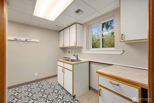 24390 Mount Washington View Ln NW, Poulsbo, WA 98370 - kitchen with a sink, a paneled ceiling, light countertops, white cabinetry, and baseboards
