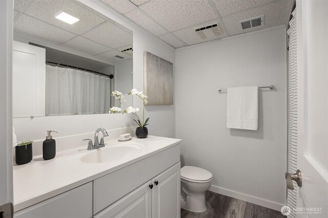 24390 Mount Washington View Ln NW, Poulsbo, WA 98370 - full bathroom featuring a drop ceiling, wood finished floors, toilet, vanity, and baseboards