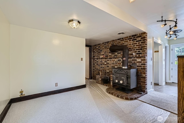 625 5th Ave S, Kent, WA 98032 - unfurnished living room featuring a wood stove, baseboards, carpet floors, and brick wall