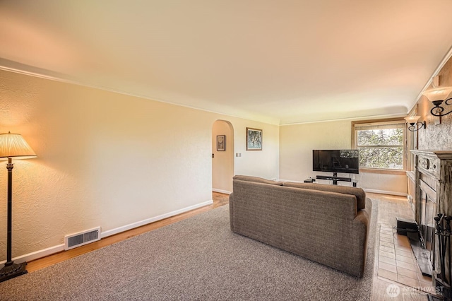 10758 22nd Ave SW, Seattle, WA 98146 - living area with arched walkways, wood finished floors, a fireplace with raised hearth, and baseboards
