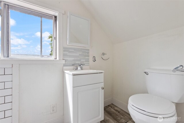 325 NW 2nd Ave, Kelso, WA 98626 - bathroom featuring vaulted ceiling, toilet, vanity, wood finished floors, and baseboards