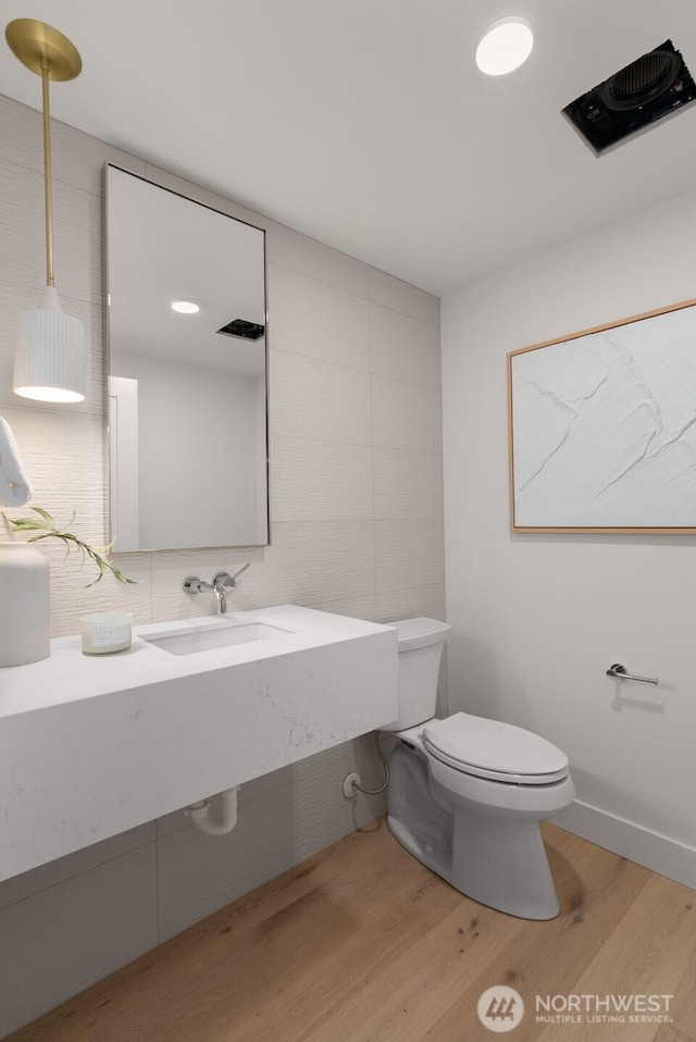 238 4th Ave Unit 101, Kirkland, WA 98033 - bathroom with wood finished floors, tile walls, backsplash, and vanity