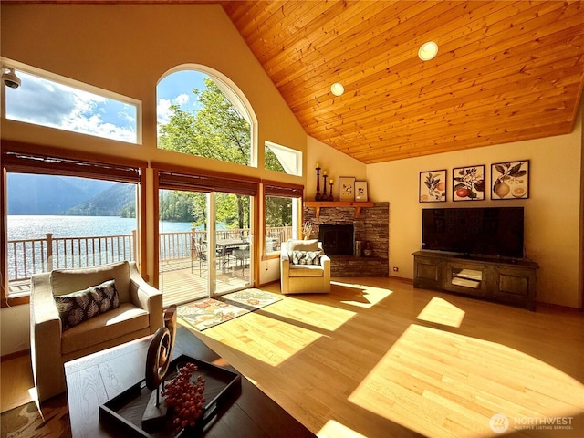441 N Potlatch Dr N, Hoodsport, WA 98548 - living room featuring high vaulted ceiling, wood finished floors, wood ceiling, a stone fireplace, and a water view