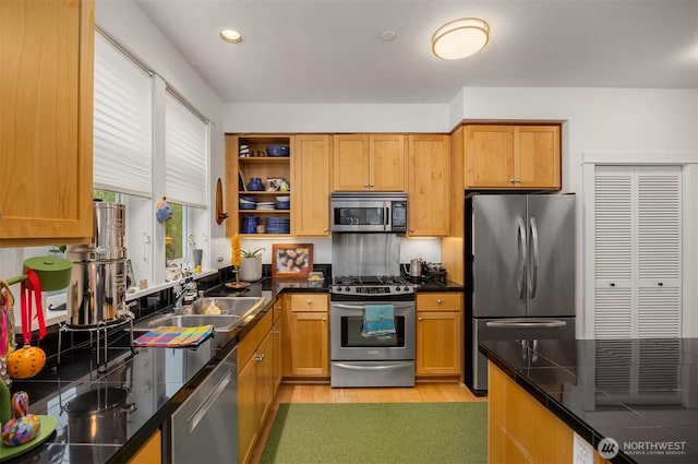 156 Hall Brothers Loop NE Unit 201, Bainbridge Island, WA 98110 - kitchen with stainless steel appliances, a sink, dark countertops, light wood-style flooring, and open shelves