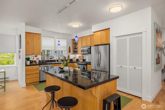 156 Hall Brothers Loop NE Unit 201, Bainbridge Island, WA 98110 - kitchen with appliances with stainless steel finishes, a breakfast bar area, light wood-type flooring, open shelves, and rail lighting
