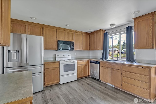 9201 S G St, Tacoma, WA 98444 - kitchen with stainless steel appliances, light countertops, light wood-style floors, a sink, and recessed lighting