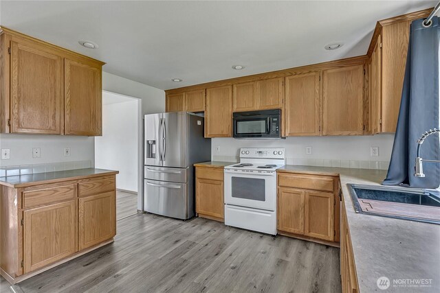 9201 S G St, Tacoma, WA 98444 - kitchen featuring stainless steel refrigerator with ice dispenser, electric range, black microwave, light wood-type flooring, and a sink