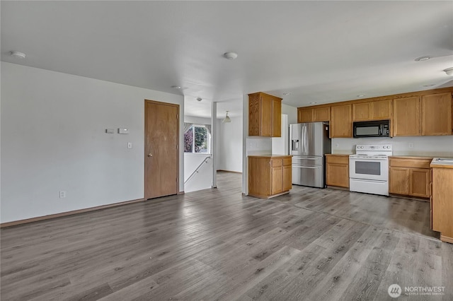 9201 S G St, Tacoma, WA 98444 - kitchen featuring electric range, black microwave, stainless steel refrigerator with ice dispenser, light wood-style floors, and light countertops