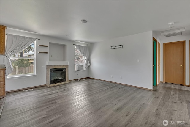 9201 S G St, Tacoma, WA 98444 - unfurnished living room with wood finished floors, a tile fireplace, and baseboards