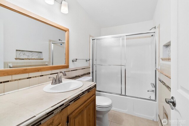 495 Lakeside Dr, Sedro Woolley, WA 98284 - full bath featuring toilet, vanity, tile patterned floors, decorative backsplash, and shower / bath combination with glass door