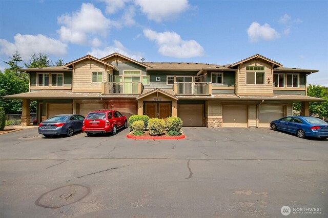 15325 SE 155th Pl Unit N5, Renton, WA 98058 - multi unit property featuring an attached garage, a balcony, driveway, and stone siding