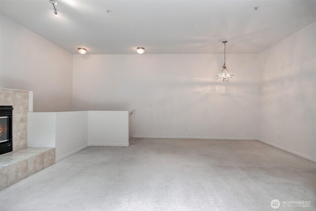 15325 SE 155th Pl Unit N5, Renton, WA 98058 - unfurnished living room with light carpet, a tile fireplace, baseboards, and a chandelier