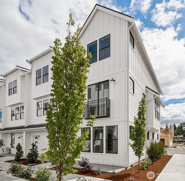 12111 127th Avenue Ct E Unit 92, Puyallup, WA 98374 - view of home's exterior with board and batten siding, a balcony, and ac unit