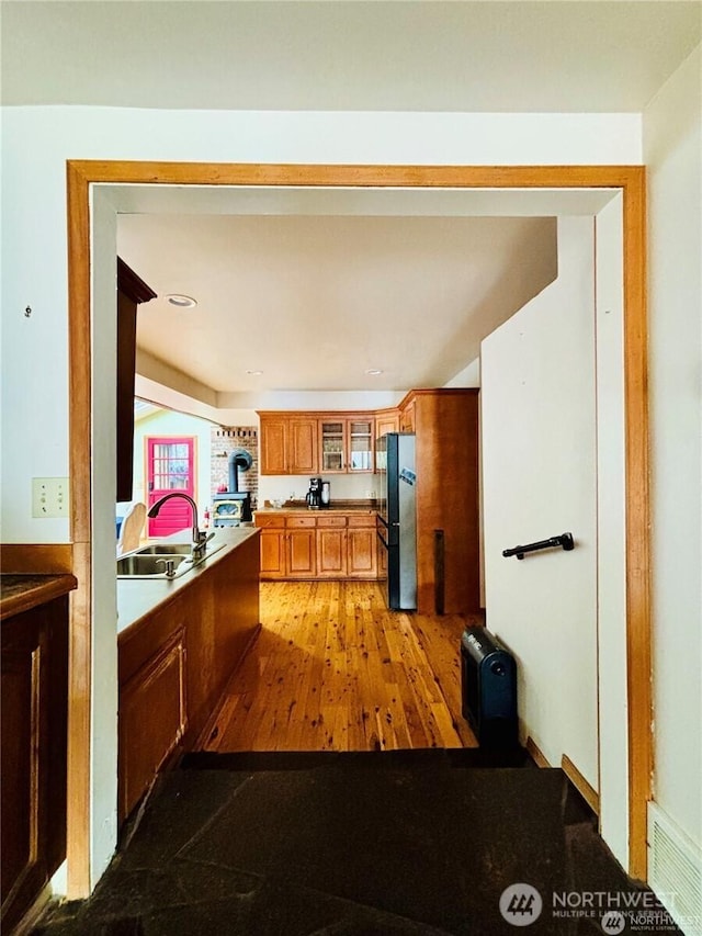 1311 SW Lake Roesiger Rd, Snohomish, WA 98290 - kitchen featuring freestanding refrigerator, a sink, brown cabinets, and glass insert cabinets