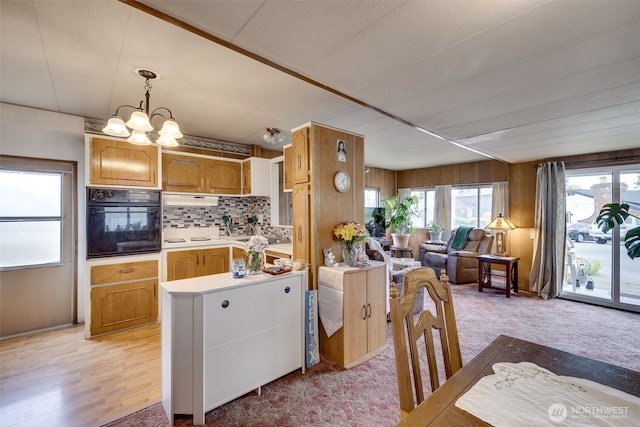 18501 52nd Ave W Unit 44, Lynnwood, WA 98037 - kitchen featuring black oven, open floor plan, a chandelier, light countertops, and tasteful backsplash