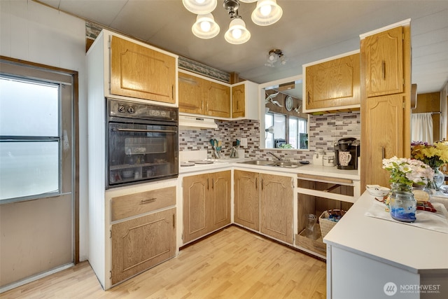 18501 52nd Ave W Unit 44, Lynnwood, WA 98037 - kitchen with oven, tasteful backsplash, light wood-style flooring, light countertops, and a chandelier